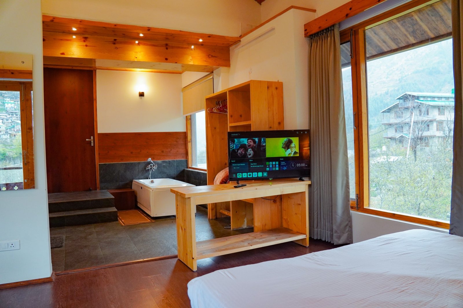 The bathtub suite — tub, television and pine walls